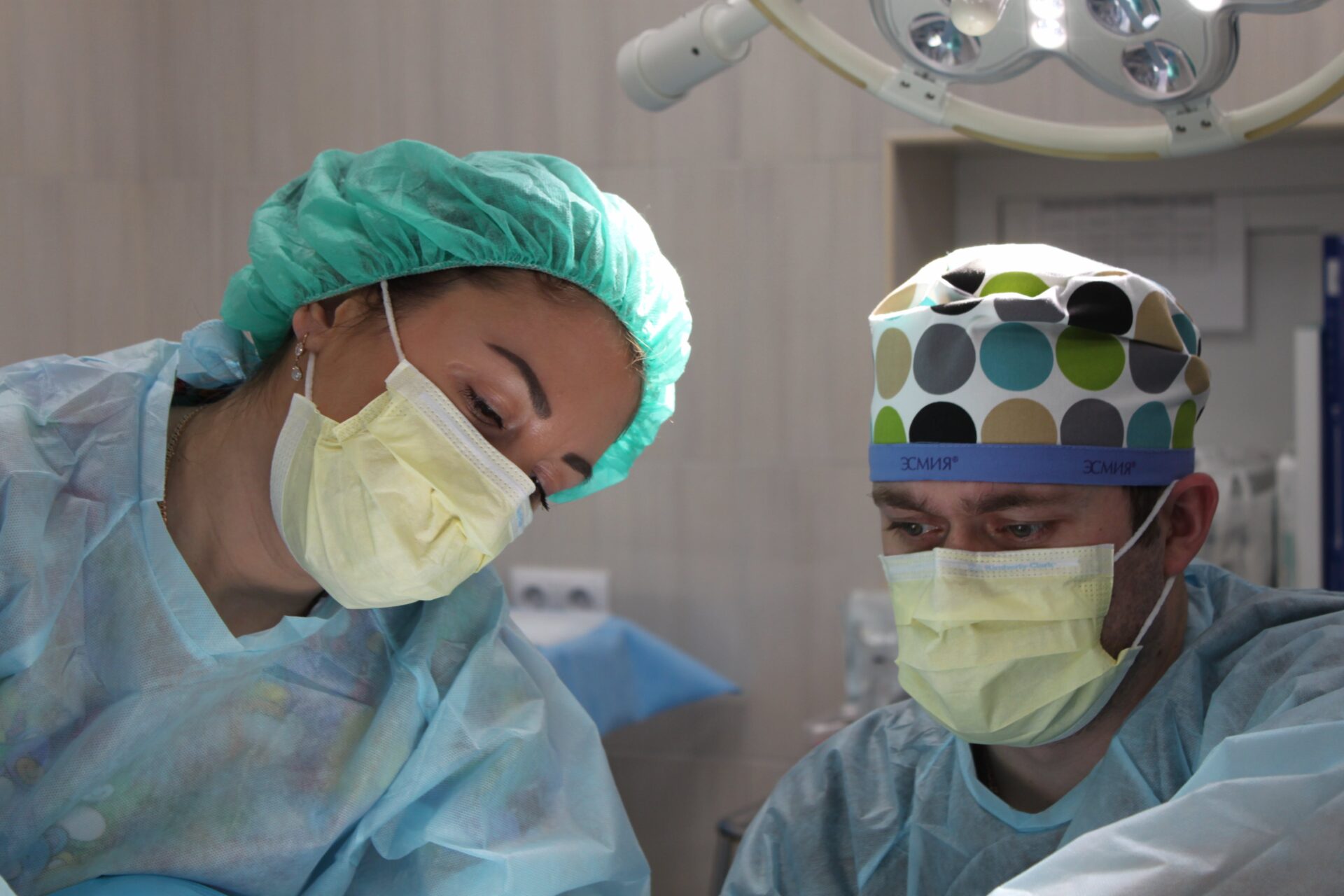 wo focused healthcare professionals in scrubs and surgical masks during a medical procedure