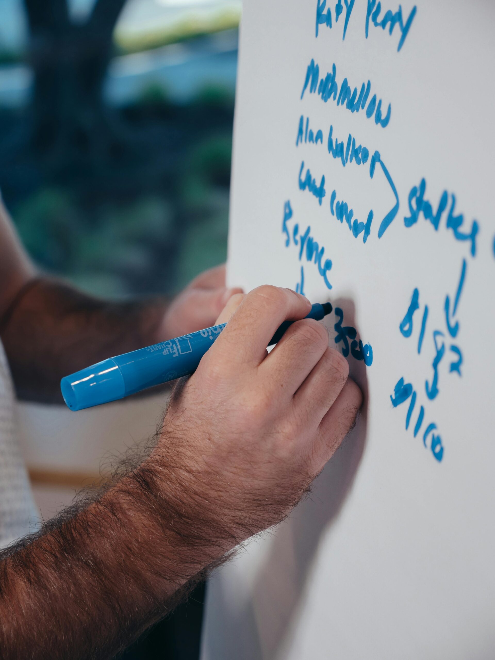 A person writing on a whiteboard to explain what is the benefit of using SOAP notes in healthcare.