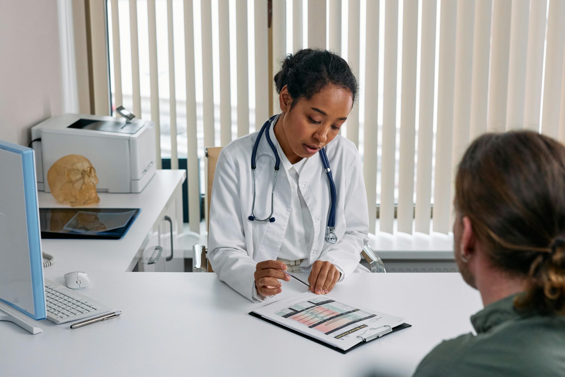 Nurse explaining medical details to a patient during a consultation, nurse paper documentation in hand.